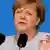 Канцлер ФРГ Ангела Меркель произносит речь перед двумя микрофонами