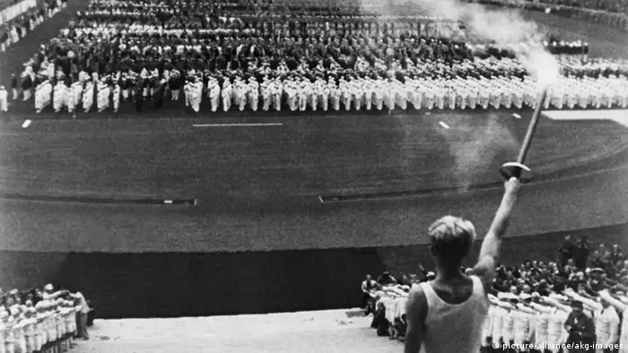 Ein Sportler entzündet das olympische Feuer bei den Olympische Sommerspielen von Berlin 1936 (picture-alliance/akg-images)