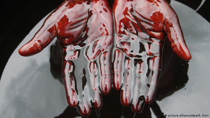 Zwei Hände, die in Erdöl getaucht sind (Foto: Picture Alliance)