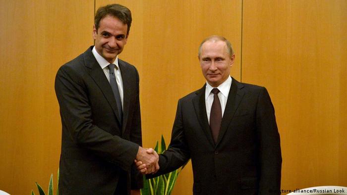 Kyriakos Mitsotakis shakes ands with Vladimir Putin