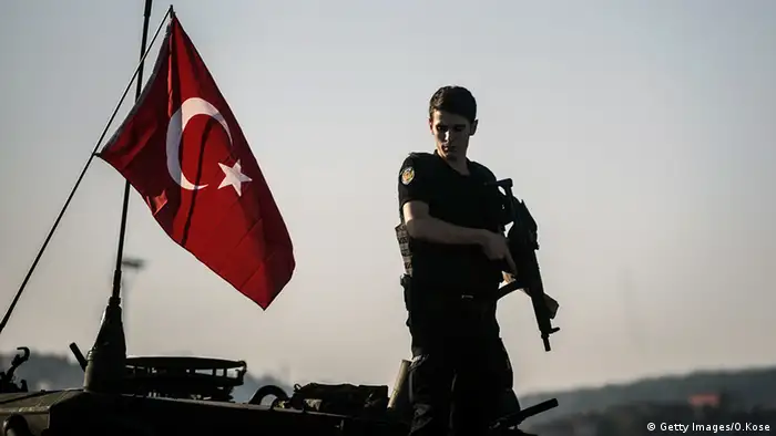 Türkei Polizist auf einem Panzer neben türkischer Flagge