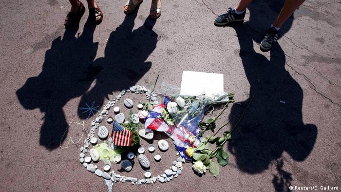 People, shadows on ground, small pile of flowers
Copyright: Reuters/E. Gaillard