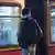 Adolescente visto de costas diante de vagão de metrô