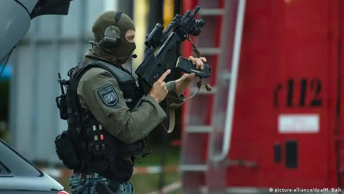 Deutschland Polizist mit Spezialausrüstung steht nahe dem Einkaufszentrum