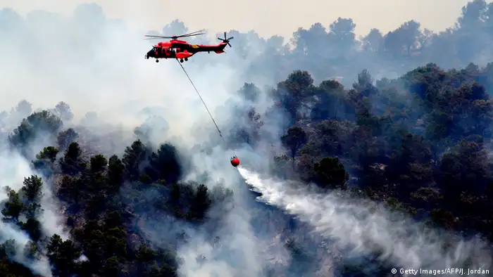 A helicopter drops water on a wildfire burning in Artana, near Castellon, eastern Spain, on July 26, 2016 (Photo: Getty Images/AFP/J. Jordan)