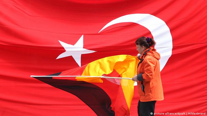 Женщина с немецким флагом на фоне турецкого флага