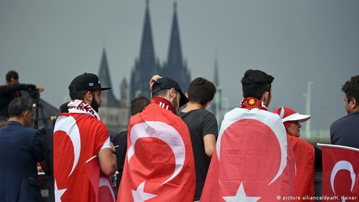 Drei junge Männer tragen die türkische Fahne in einer Pro-Erdogan-Demonstration in Köln, 2016