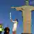Die ehemalige brasilianische Volleyball-Spielerin Isabel Barroso hält an der Cristo-Statue die olympische Flamme in die Luft (Foto: Reuters/P.Olivares)