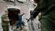 Rebels inspect a shelled building Rebels inspect a shelled building