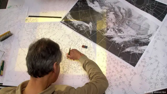 Meteorologe zeichnet Wetterfronten auf einer Europakarte