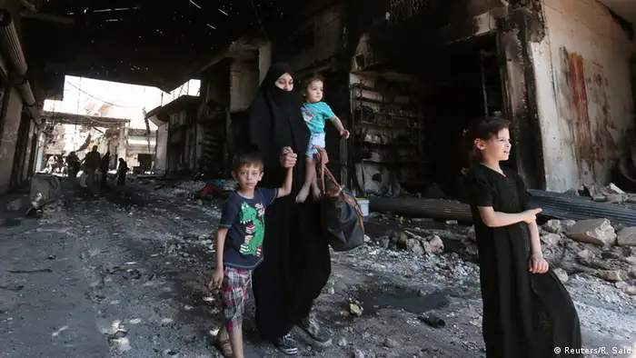 Syrien Manbij bei Aleppo Frau mit Kindern zwischen Trümmern