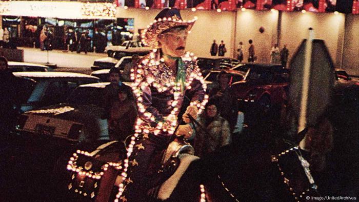 Robert Redford sitzt in einer Szene des Films Der elektrische Reiter in einem beleuchteten Kostüm auf einem Pferd.