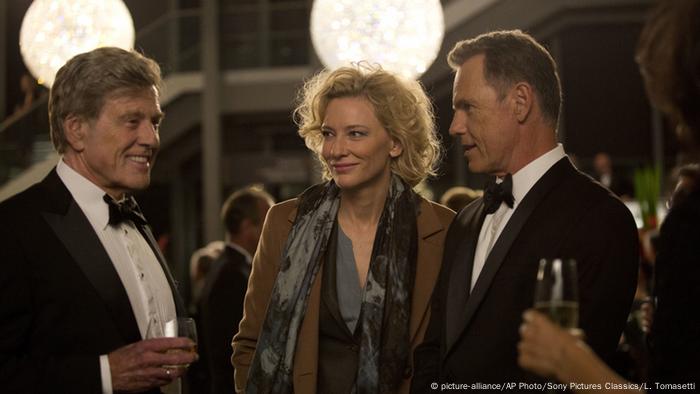 Robert Redford steht im Film Der Moment der Wahrheit bei einem Empfang neben einem Paar.