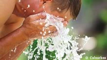 A man refreshes himself with a splash of cool, fresh water on his face. Copyright: Colourbox