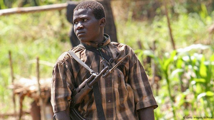 Un enfant-soldat de la LRA au Soudan, avec un AK-47 en bandoulière