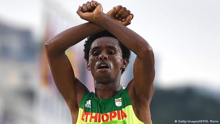  Feyisa Lilesa with arms crossed above his head.(Getty Images/AFP/O. Morin)
