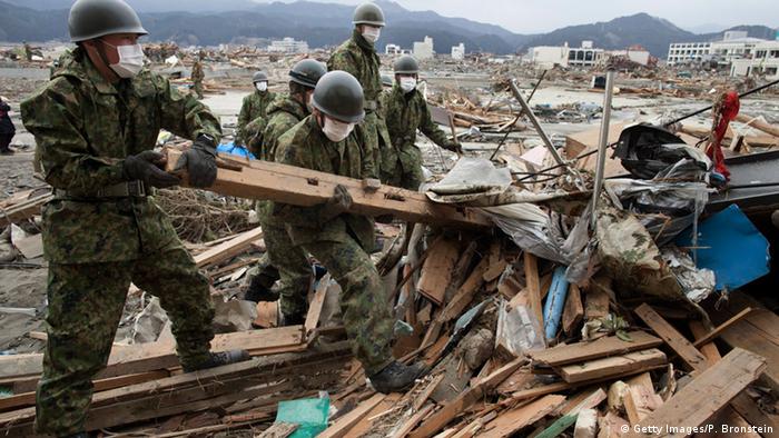 Militares japoneses buscan cuerpos entre los escombros en un pueblo destruido por el tsunami en Rikuzentakata (15.03.2011)