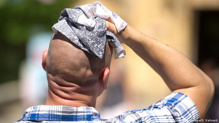 Man wiping his head (picture-alliance/dpa/S. Kahnert)