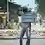 Mann hält ein Straßenschild in Bujumbura
