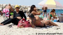 29.08.2016 *** In this image taken from video, Nesrine Kenza who says she is happy to be free to wear a burkini, and two unidentified friends rest on the beach in Marseille, France, Monday Aug. 29, 2016. A high court struck down the previous ban of the wearing of so called burkini Friday, but the debate revealed raw tensions between the secular establishment and sectors of France's estimated 5 million Muslims. (AP Photo) Copyright: picture-alliance/AP Photo