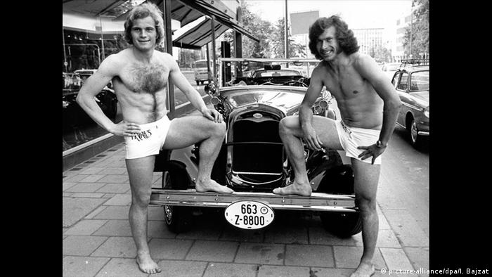 Uli Hoeneß und Paul Breitner posieren in Badehosen vor einem Oldtimer Foto: picture-alliance/dpa/I. Bajzat