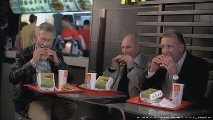 Horst Eckel, Paul Breitner und Andi Brehme essen Bürger (c) youtube/Christoph Koch Fine Art Photography/Screenshot)