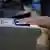 A passenger places his fingers into a scanning device.