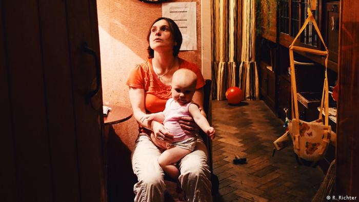 Die Bewohnerin Polina mit ihrem Baby Alexandra auf dem Schoß (Foto: DW/R. Richter)