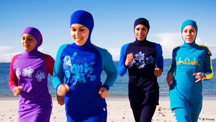 Women in burkinis jogging down the beach (Privat)