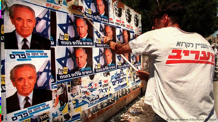 Israel Wahlkampf 1996 - rechter Aktivist überklebt Plakate von Schimon Peres (picture-alliance/COLORplus/P. Guyot)