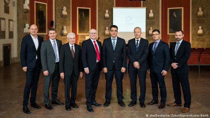 Future Prize nominees: eight men in suits standing in a line. (Photo: obs/Deutscher Zukunftspreis/Lukas Barth)