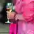 A woman in a bright pink dress holding a glass of champagne