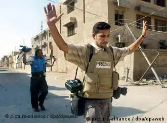 Zwei Journalisten in der irakischen Stadt Nadschaf heben die Arme, um nicht beschossen zu werden - ein Archivfoto vom August 2004. Journalisten im Irak leben weiterhin gefährlich