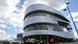 The Mercedes Museum with several cars parked in front in Stuttgart The Mercedes Museum with several cars parked in front in Stuttgart