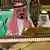 Mann mit rotem arabischem Kopftuch sitzt hinter einem Rednerpult (Quelle: dpa)