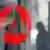 ** ARCHIV ** Ein Mann laeuft hinter einer Glasscheibe mit dem Logo der Agentur fuer Arbeit in Muenchen vorbei. Quelle: AP