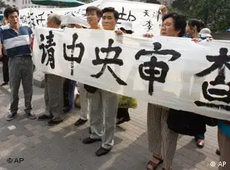 Tianjin residents protest outside the Chinese Construction Ministry in Beijing, China, Wednesday, June 21, 2006. Investigators have questioned three top officials in the northern Chinese port of Tianjin over alleged corruption tied to shady real estate deals, a human rights group said Wednesday. The allegations come amid protests by Tianjin residents over what they say are forced evacuations being directed by officials out for personal profit. The Chinese words read Central Government please investigate. (AP Photo/Ng Han Guan)