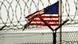 US-Flagge hinter Stacheldraht-Zaun in Guantanamo US-Flagge hinter Stacheldraht-Zaun in Guantanamo