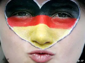 A woman with a heart painted on her face in the colors of the German flag