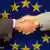 A handshake in front of the European Union flag