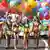 A row of colorfully painted women with balloons