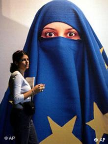 A visitor passes by Turkish artist Burak Delier's work Untitled which shows a woman covered by a EU flag