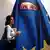 Žena ispred plakata na kojemu je nosačica burke u bojama EU-a
