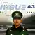 A Chinese soldier stands in front of an Airbus 380 plane