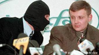 Alexander Litwinenko mit einem maskierten FSB-Agenten