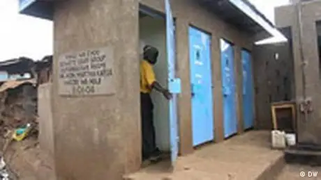 A man goes into a cubicle in a toilet block in Kibera