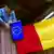 Ein älterer Rumäne hängt eine Europa-Flagge neben die rumänische Flagge an seinem Balkon (Bild: AP)