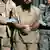 Ein Gefangener im Camp Delta des US-Stützpunkts Guantanamo wird von Wächtern abgeführt (AP Photo/Brennan Llinsley)