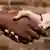 A black and a white hand shaking