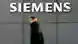 Прохожий на фоне логотипа Siemens